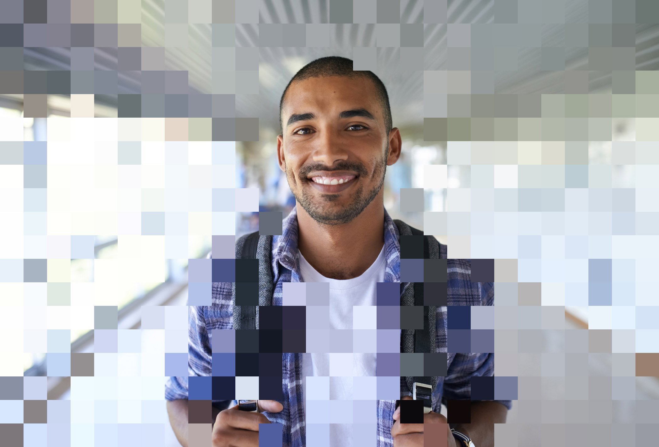 Portrait of a happy young man standing in a corridor on campus